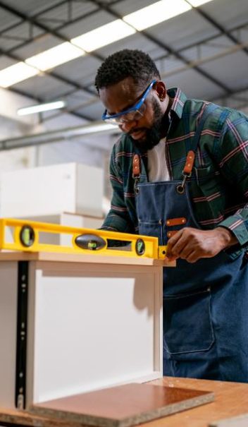 carpenter-using-sander-while-working-on-a-piece-of-2023-11-27-05-32-19-utc