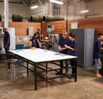 engineers-working-on-machines-in-busy-metal-worksh-2024-10-20-10-43-39-utc